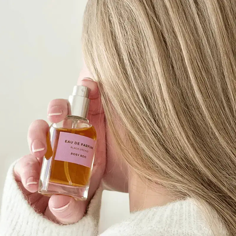 Woman sampling Rosy Roo perfume.