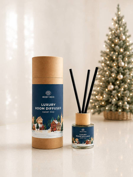 Rosy Roo luxury room diffuser set with black reeds beside its box, styled in front of a lit Christmas tree.